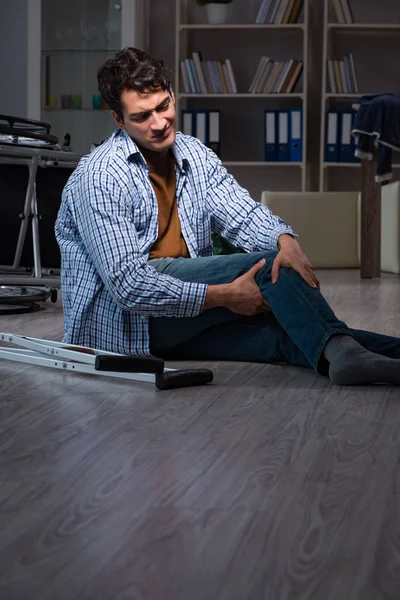 Egy férfi leesett a kerekesszékről a padlón ülve. — Stock Fotó