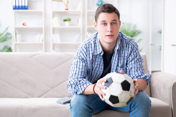 Giovane studente guardando il calcio a casa — Foto Stock