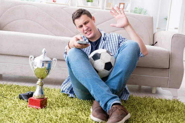 Jovem estudante assistindo futebol em casa — Fotografia de Stock