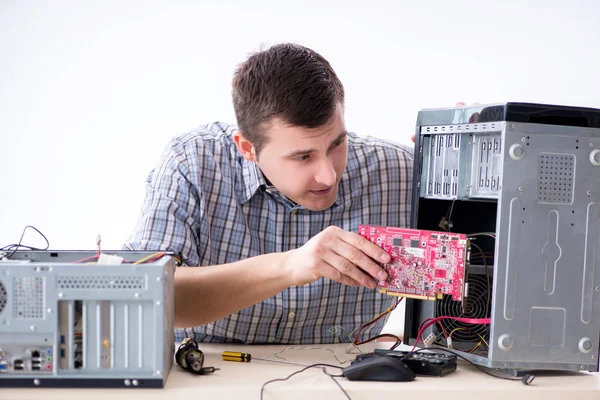 Young technician repairing computer in workshop