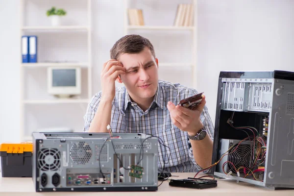 Young technician repairing computer in workshop — Stock Photo, Image