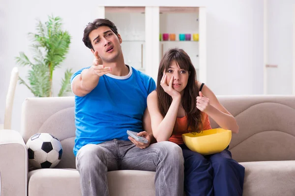 年轻人和他的妻子在家里看足球 — 图库照片