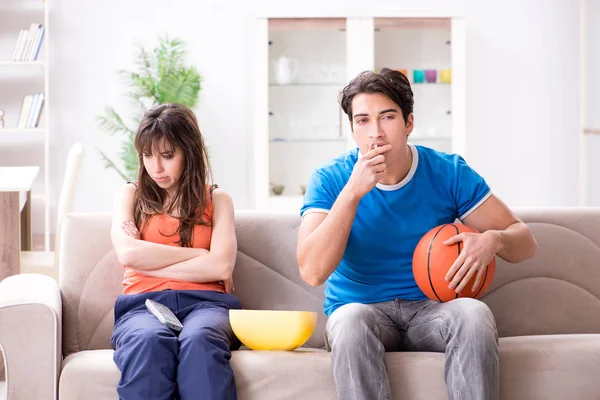 Egy férfi kosárlabdát néz a feleségével. — Stock Fotó