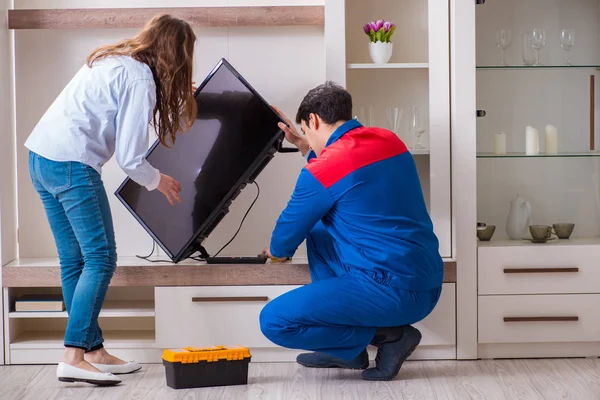 Repairman repairing tv at home