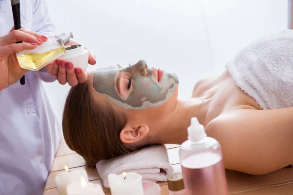 Ung kvinna i spa hälsa koncept med ansiktsmask — Stockfoto