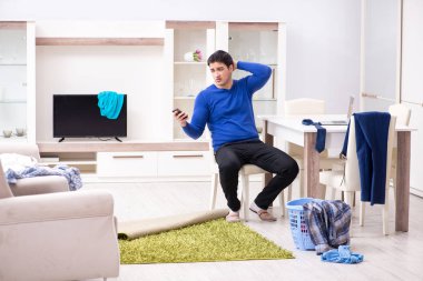 Genç adam çamaşırhane için kirli çamaşır topluyor.