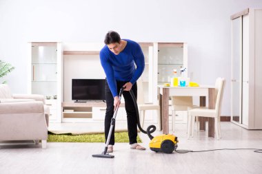 Genç adam evini temizliyor.