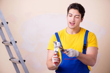 Duvara alçı yapıştıran genç müteahhit.