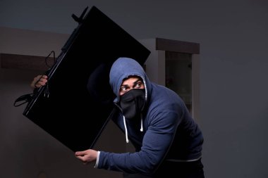 Hırsız, apartmandan televizyon çalıyor.