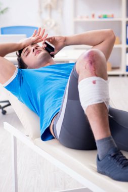 Spor sakatlığı geçiren hasta doktoru ziyaret ediyor.