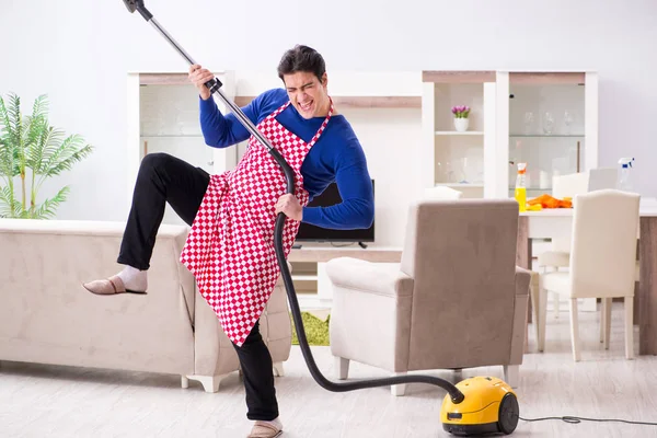 Joven hombre aspiradora limpieza de su apartamento —  Fotos de Stock