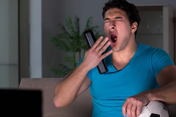 Young man watching football late at night — Stock Photo, Image