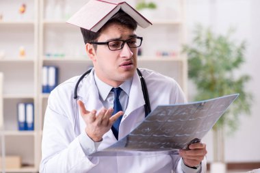 Genç doktor klinikteki röntgen görüntülerine bakıyor.