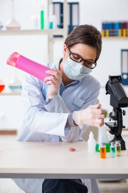 Laboratuar kimyageri güzellik ve makyaj ürünlerini kontrol ediyor.