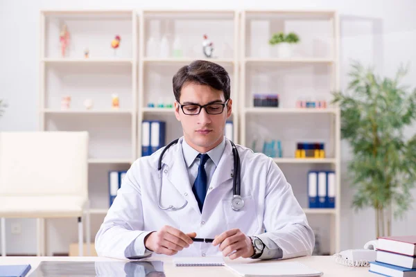 Jeune médecin assis dans le bureau — Photo