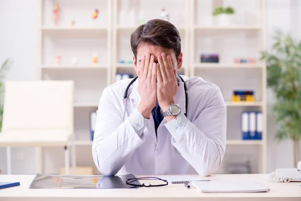 Jovem médico sentado no escritório — Fotografia de Stock