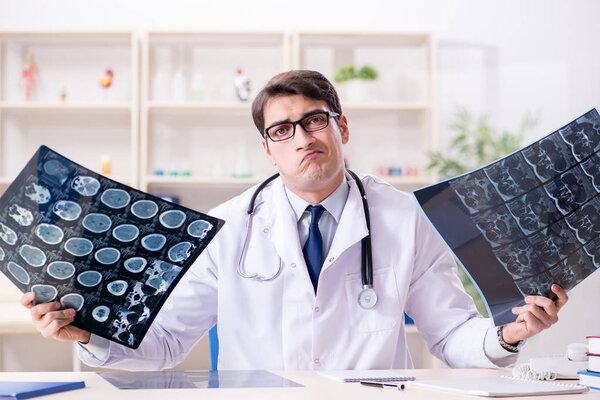 Young doctor looking at x-ray images in clinic