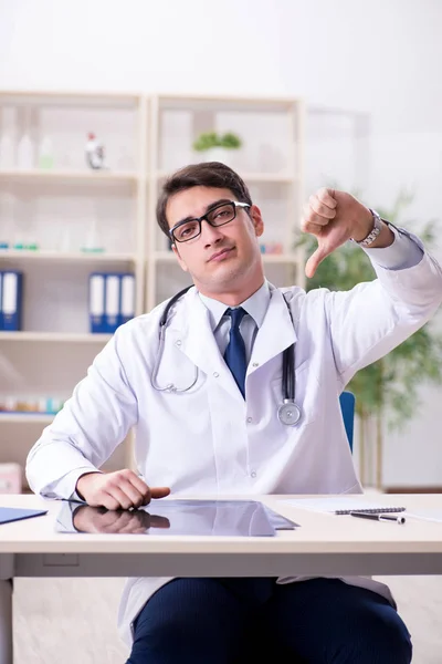 Junger Arzt sitzt im Büro — Stockfoto