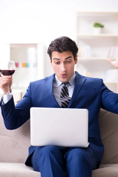 Бізнесмен п'є вино, сидячи вдома — стокове фото