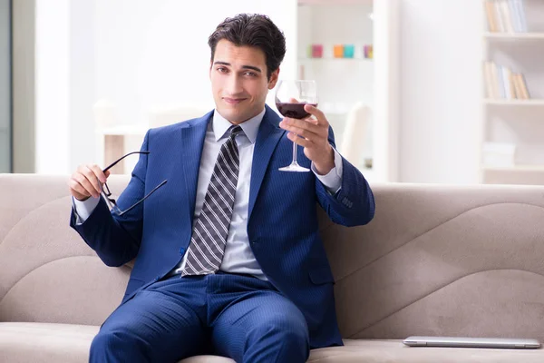 Empresario bebiendo vino sentado en casa — Foto de Stock