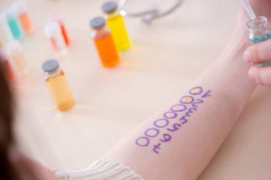 Hastanedeki hastanın alerji reaksiyonunu test eden doktor.