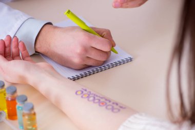 Hastanedeki hastanın alerji reaksiyonunu test eden doktor.