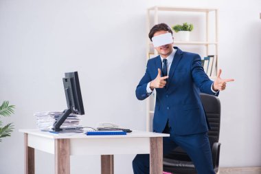 Çalışan ofiste sanal gerçeklik gözlüğü kullanıyor.