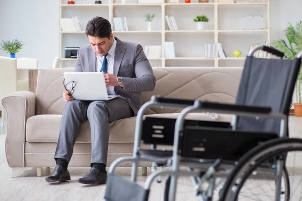 Homme d'affaires en fauteuil roulant travaillant à domicile — Photo