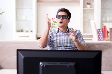 Evde 3D televizyon izleyen bir adam.