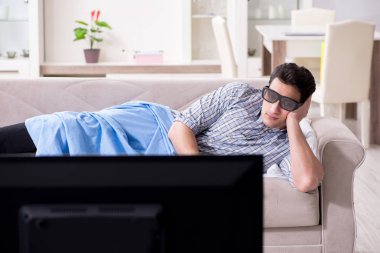 Evde 3D televizyon izleyen bir adam.