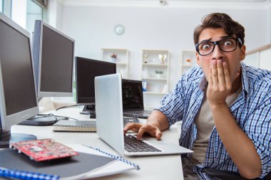 Birçok ekranın önünde oturan bir iş adamı