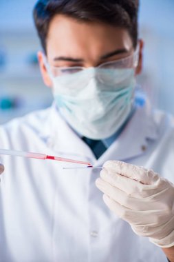 Laboratuvar asistanı hastanede kan örneklerini test ediyor.