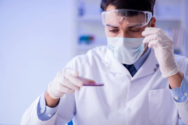 Laboratuvar asistanı hastanede kan örneklerini test ediyor.