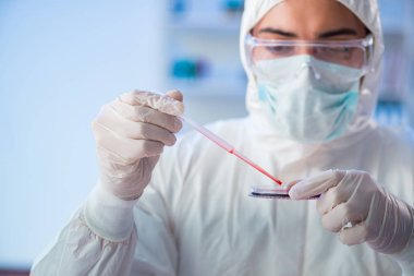 Laboratuvar asistanı hastanede kan örneklerini test ediyor.