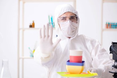 Plastik tabakları kontrol edip test eden kimyager.