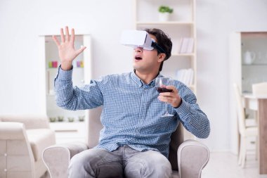 Genç adam evde şarap içiyor.