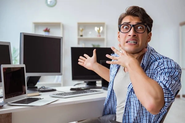 Empresario sentado frente a muchas pantallas — Foto de Stock