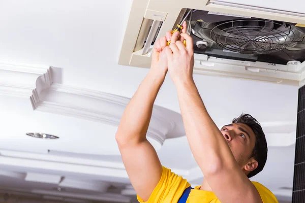 Repairman repairing ceiling air conditioning unit — Stock Photo, Image