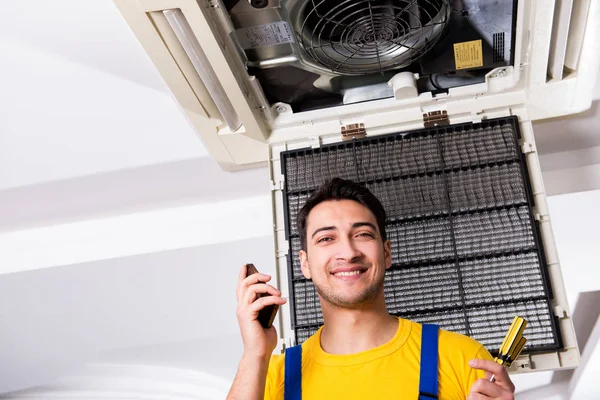 Reparador reparando la unidad de aire acondicionado del techo — Foto de Stock