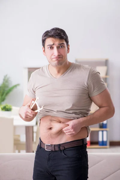 Hombre midiendo grasa corporal con pinzas — Foto de Stock