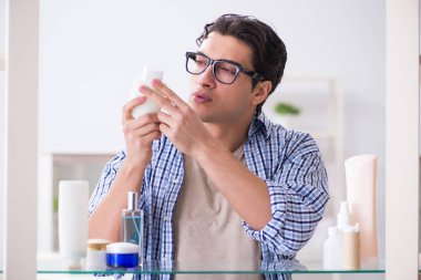 Genç adam banyoda çalışmak için hazırlanıyor.