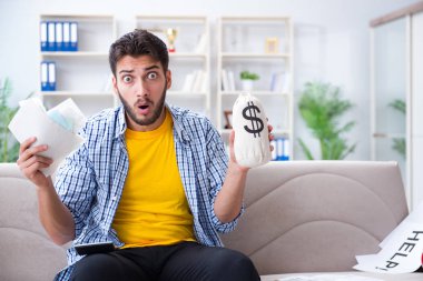 Ödeme yapması gereken faturalara kızgın bir adam.