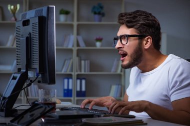 Genç adam fazla mesai yapmak için geç saatlere kadar ofiste kalıyor.