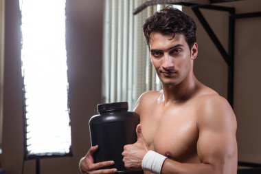 Spor salonunda besin takviyesi olan bir adam.