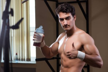 Spor salonunda besin takviyesi olan bir adam.