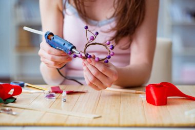 Kadın evde mücevher yapıyor.