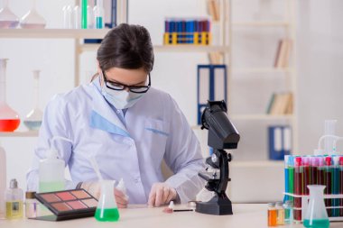 Laboratuar kimyageri güzellik ve makyaj ürünlerini kontrol ediyor.