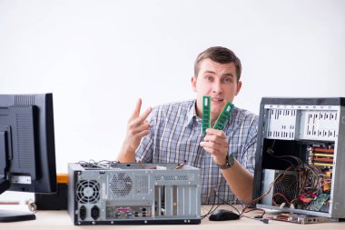 Genç teknisyen atölyede bilgisayar tamir ediyor.