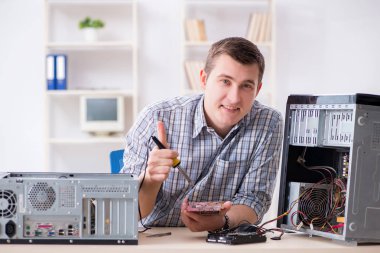 Genç teknisyen atölyede bilgisayar tamir ediyor.