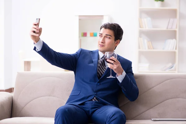 Uomo d'affari che beve vino seduto a casa — Foto Stock